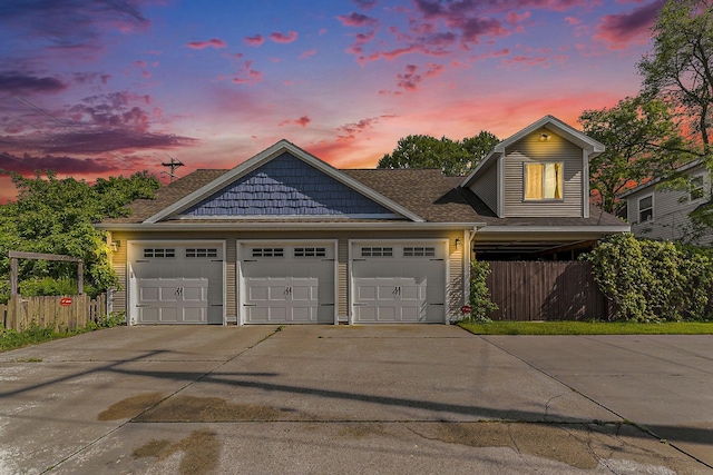 view of front of house featuring fence, driveway, and a shingled roof