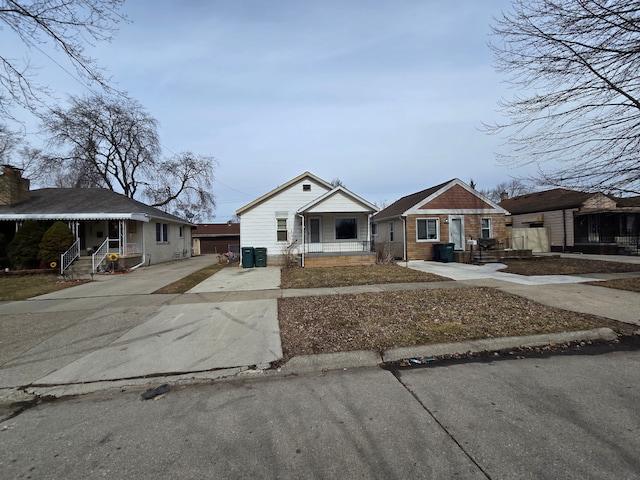 bungalow-style home featuring covered porch and concrete driveway