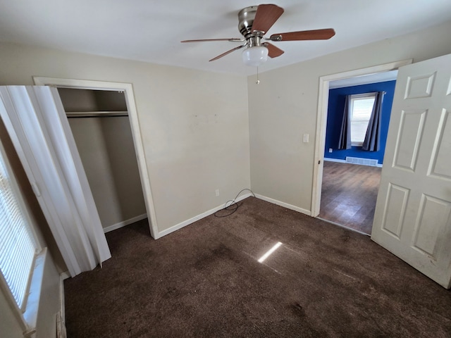 unfurnished bedroom featuring visible vents, baseboards, carpet flooring, a closet, and a ceiling fan