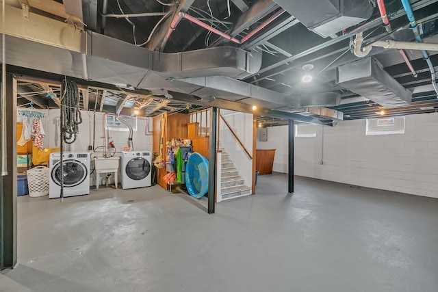 below grade area with a sink, stairway, electric panel, and washer and clothes dryer