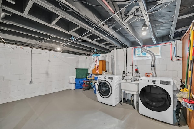 washroom with a sink, laundry area, and washer and clothes dryer