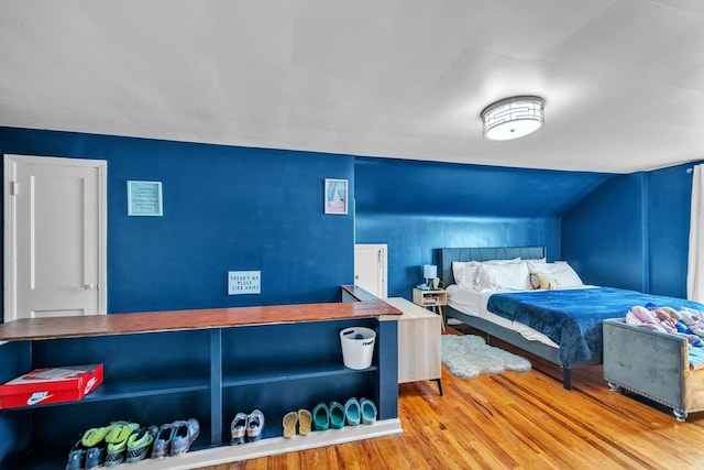 bedroom with vaulted ceiling and wood finished floors