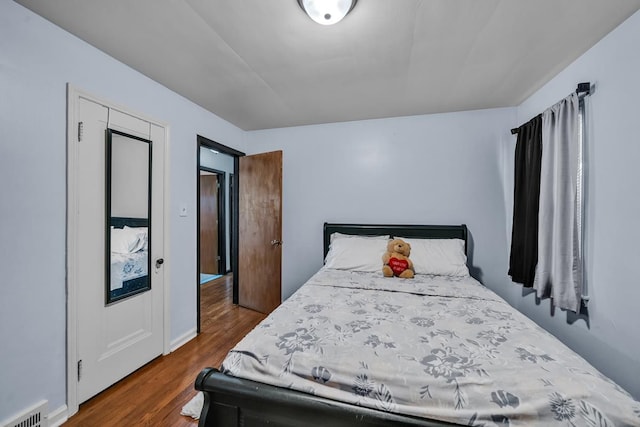 bedroom with dark wood-style floors and visible vents