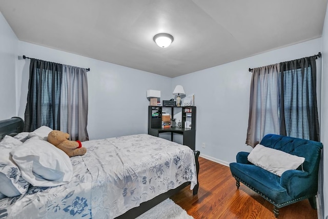 bedroom with baseboards and wood finished floors