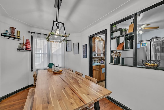 dining space featuring ceiling fan, baseboards, and wood finished floors