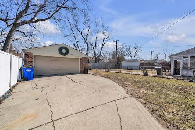 exterior space featuring an outbuilding, a garage, and fence