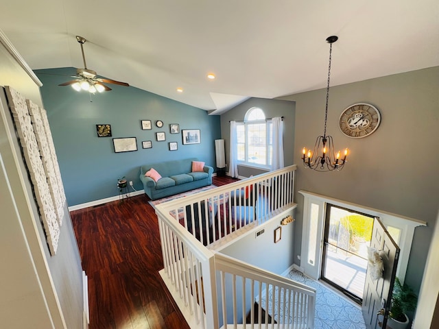 staircase featuring baseboards, vaulted ceiling, recessed lighting, an inviting chandelier, and wood finished floors