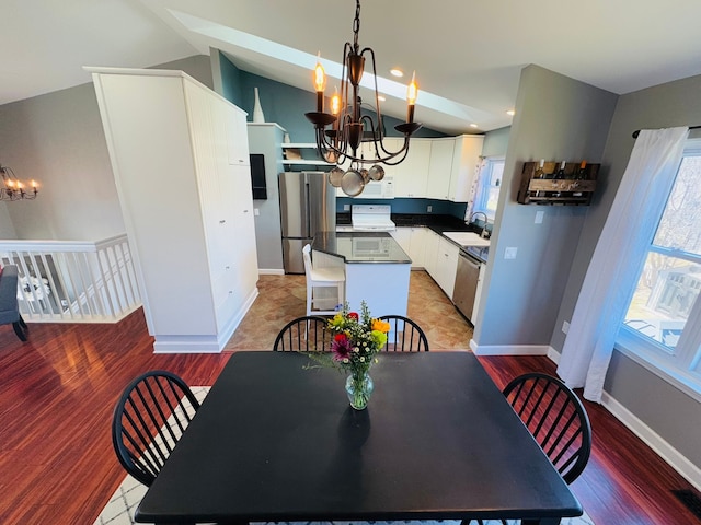 dining space with plenty of natural light, baseboards, an inviting chandelier, and vaulted ceiling