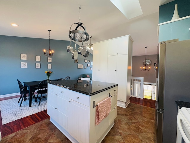 kitchen featuring white cabinetry, an inviting chandelier, hanging light fixtures, and freestanding refrigerator