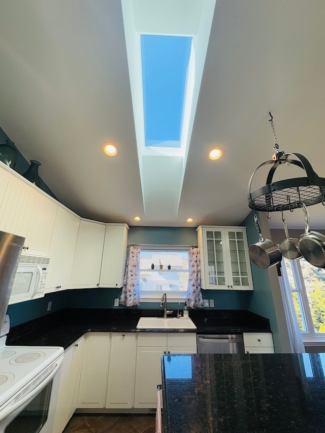 kitchen with a sink, glass insert cabinets, white appliances, and recessed lighting