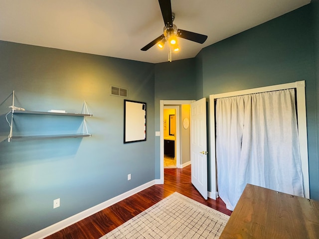 unfurnished bedroom with wood finished floors, visible vents, baseboards, ceiling fan, and vaulted ceiling