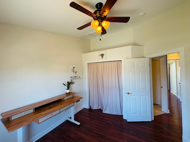 interior space with baseboards, wood finished floors, and a ceiling fan