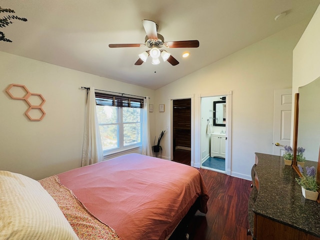 bedroom featuring a ceiling fan, ensuite bathroom, baseboards, dark wood-style flooring, and vaulted ceiling