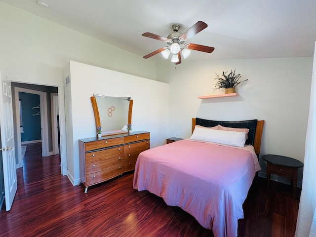 bedroom featuring visible vents, baseboards, wood finished floors, and a ceiling fan