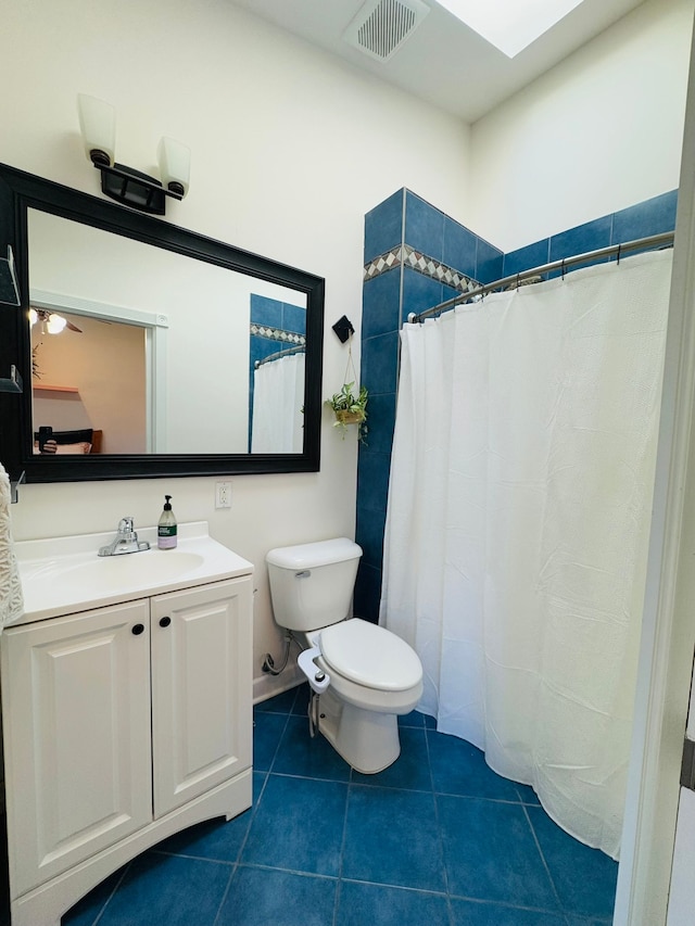 full bath featuring vanity, visible vents, a skylight, tile patterned floors, and toilet