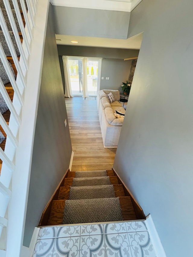 staircase with baseboards and wood finished floors