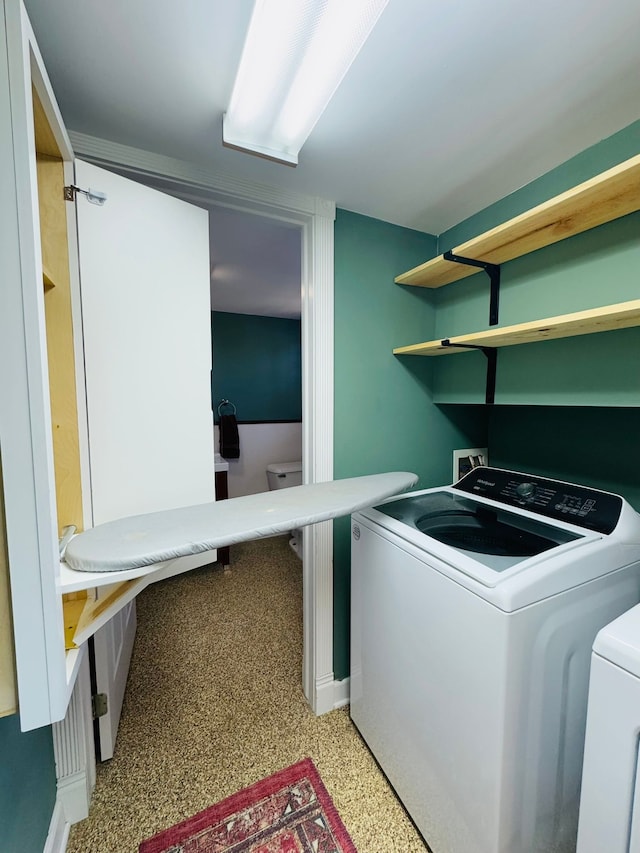 clothes washing area featuring washer and clothes dryer and laundry area