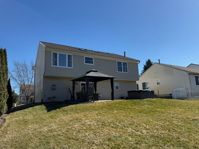 rear view of house with a gazebo and a yard