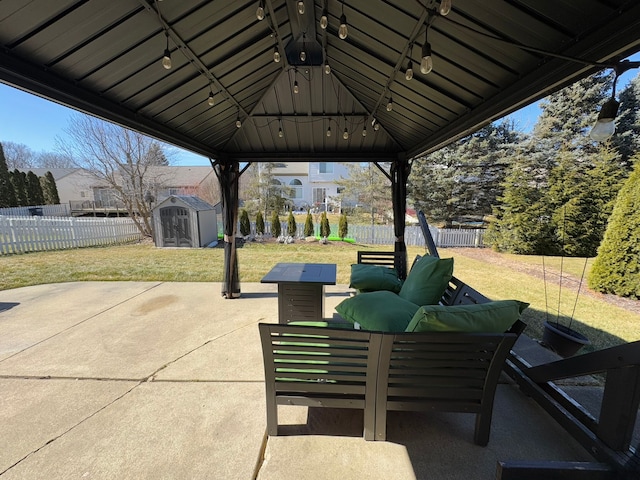 view of patio / terrace with a storage unit, an outbuilding, a fenced backyard, a gazebo, and outdoor lounge area