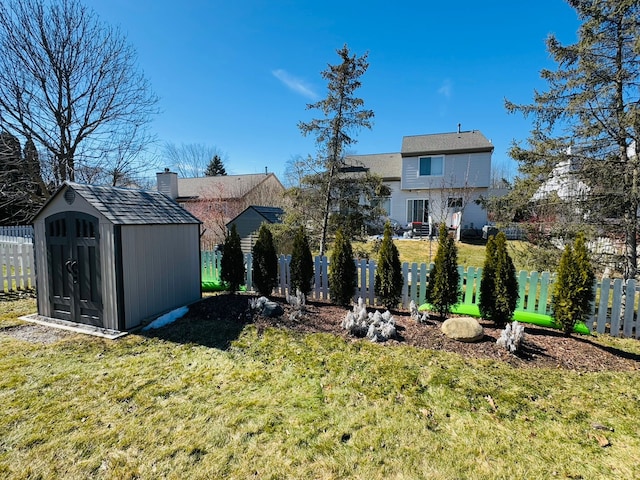 view of yard with an outbuilding, a storage shed, and fence