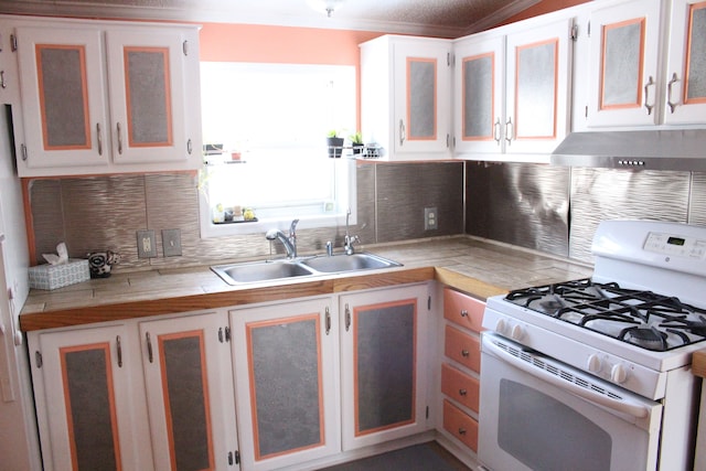 kitchen with tasteful backsplash, light countertops, white gas range oven, white cabinets, and a sink