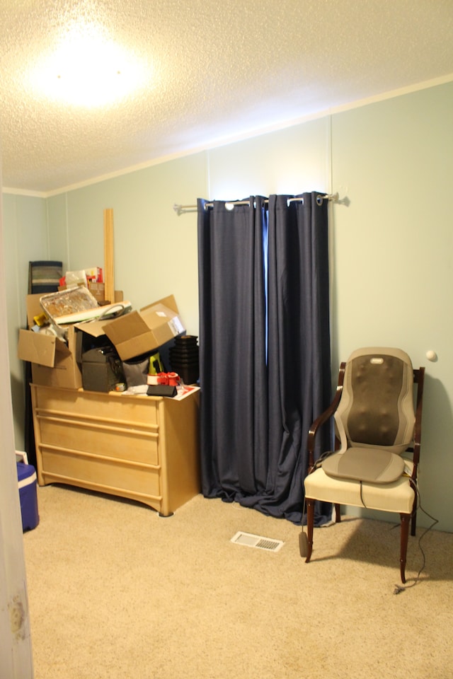 bedroom featuring visible vents, a textured ceiling, crown molding, and carpet floors