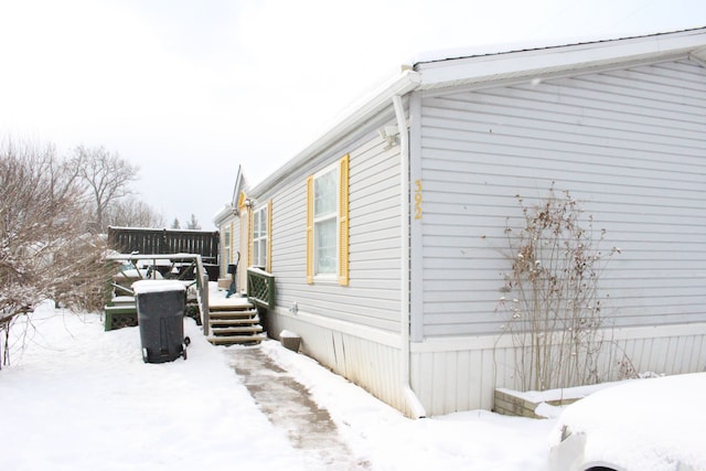 snow covered property with a deck