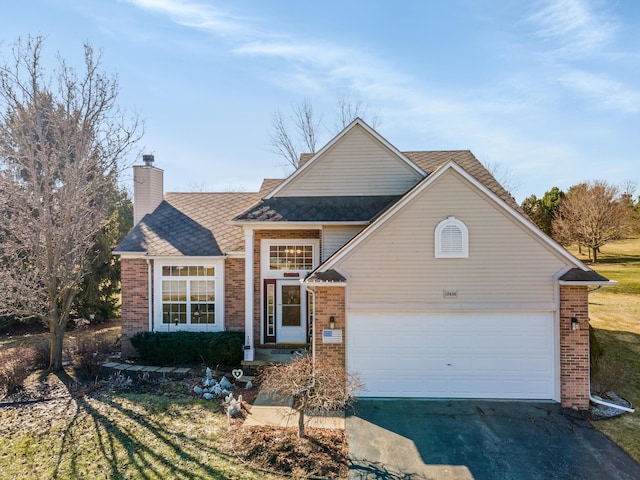 traditional-style house with an attached garage, brick siding, driveway, and a chimney