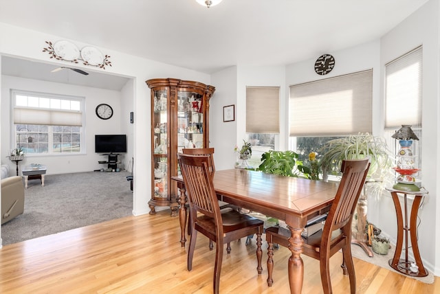 dining space featuring light carpet, baseboards, and light wood-style floors