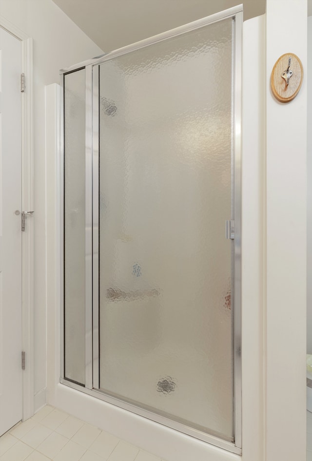 bathroom with tile patterned floors and a stall shower