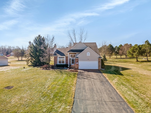 view of front of home with driveway, an attached garage, a chimney, a front lawn, and brick siding