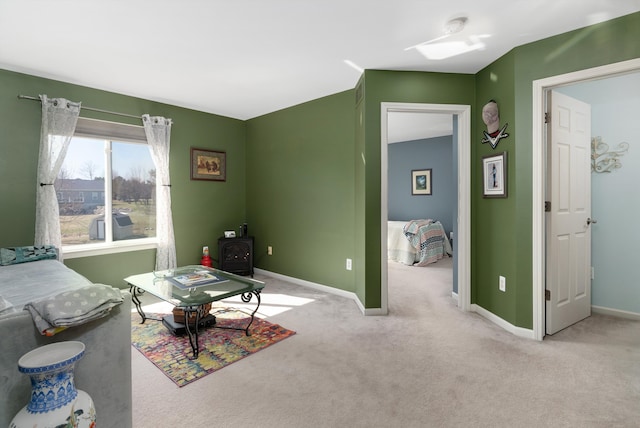 living room with baseboards, carpet floors, and a wood stove