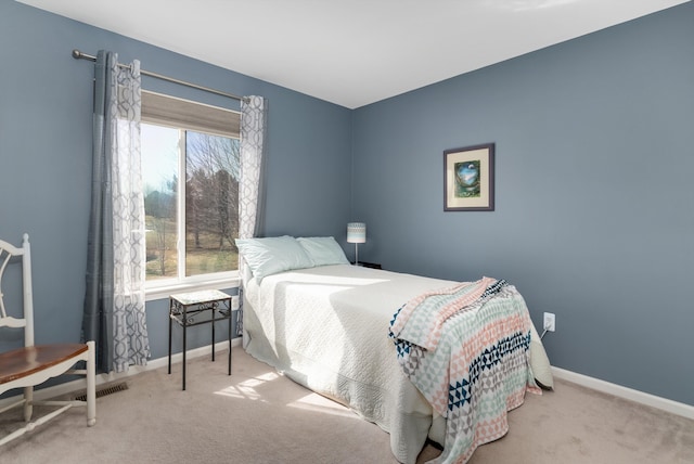 carpeted bedroom with visible vents, multiple windows, and baseboards