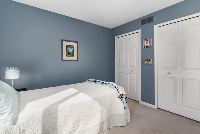 carpeted bedroom featuring visible vents and baseboards