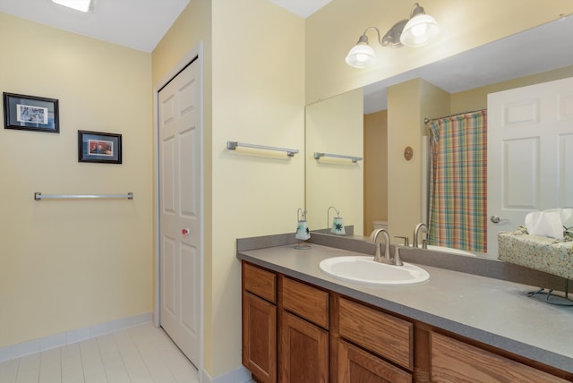 bathroom featuring tile patterned flooring, vanity, and baseboards