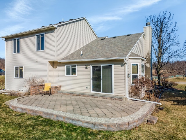 rear view of property with a yard, a patio area, and a chimney