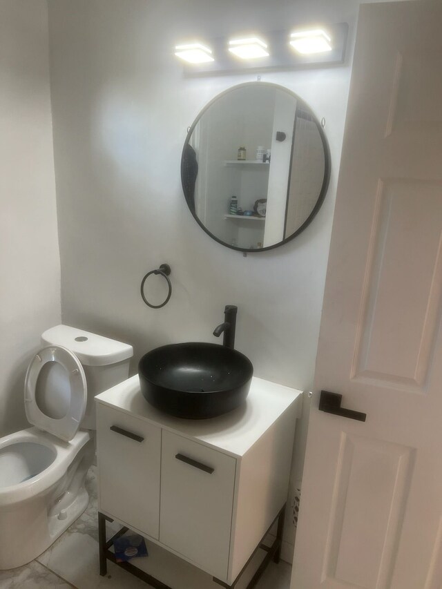 bathroom featuring marble finish floor, vanity, and toilet