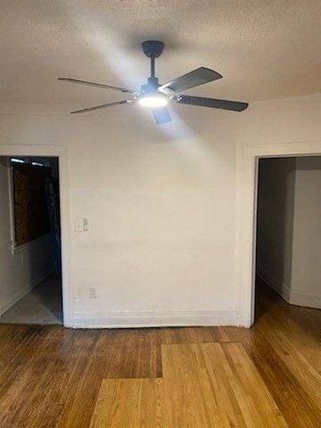 unfurnished room with baseboards, a textured ceiling, ceiling fan, and wood finished floors