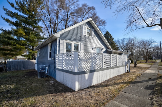 view of side of property featuring central AC unit, a wooden deck, and fence