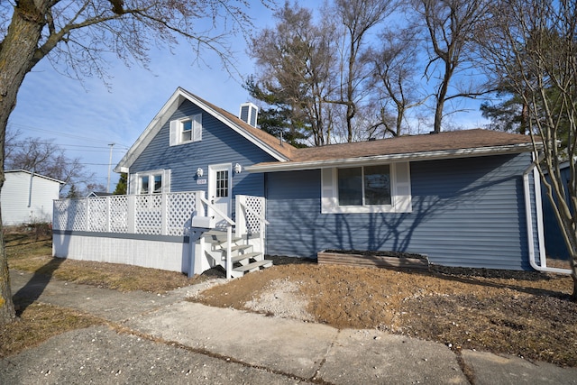 view of front facade featuring a deck and a chimney