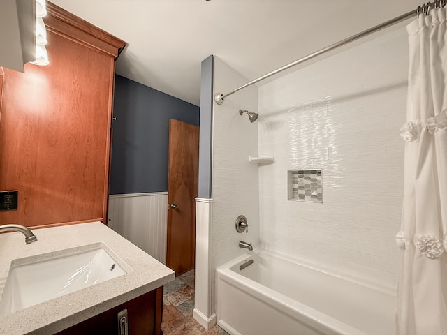 bathroom featuring vanity, shower / bath combo, and wainscoting