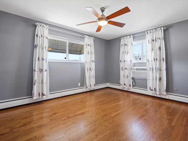 spare room featuring a ceiling fan, cooling unit, and wood finished floors