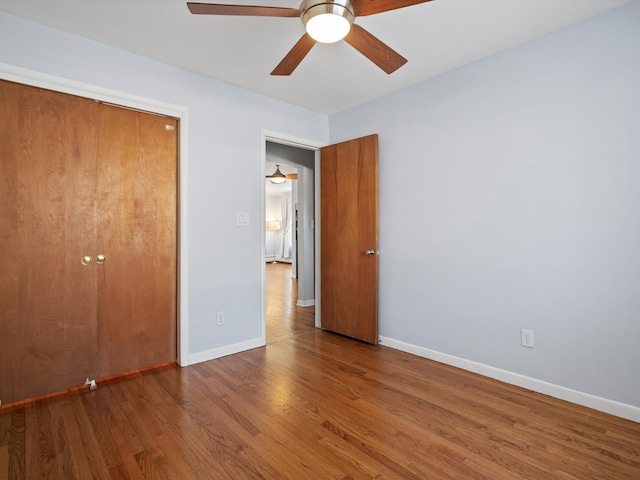 unfurnished bedroom with ceiling fan, baseboards, and wood finished floors