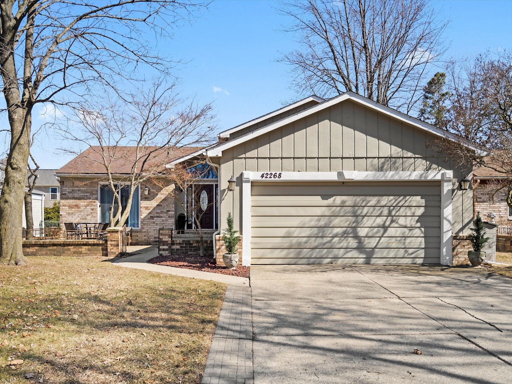 ranch-style house featuring brick siding, driveway, a front lawn, and a garage