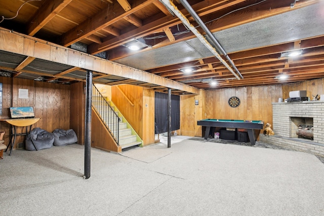 finished below grade area featuring carpet flooring, billiards, stairway, and wooden walls