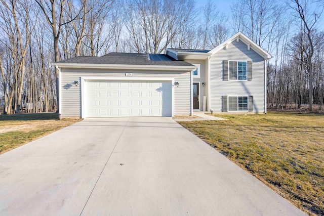 split level home featuring a garage, concrete driveway, and a front lawn