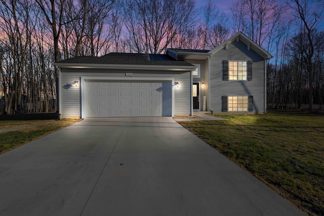 view of front of house featuring concrete driveway, an attached garage, and a front yard