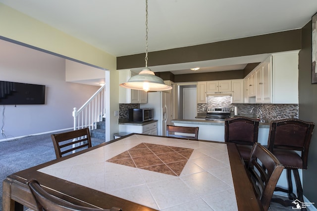 dining area with stairway, baseboards, and tile patterned flooring