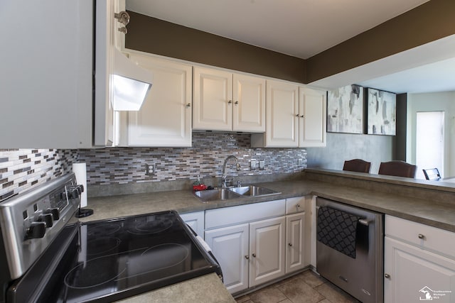 kitchen featuring a sink, stainless steel appliances, backsplash, and white cabinetry