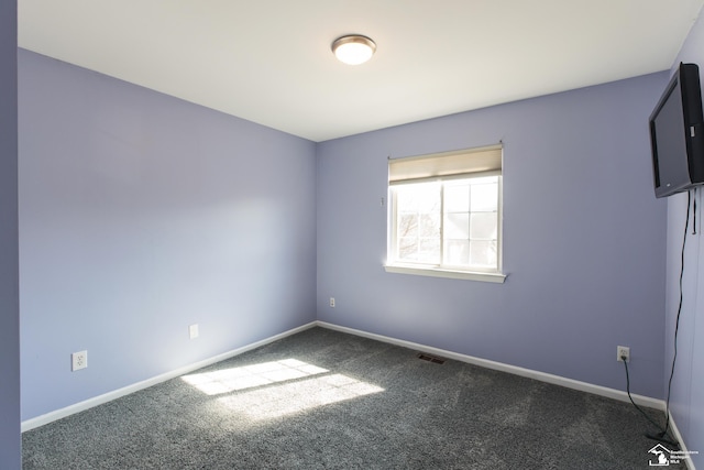 empty room featuring visible vents, baseboards, and carpet